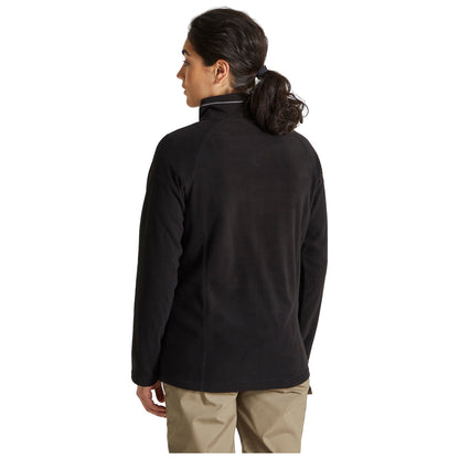 A person wearing a black fleece jacket is standing with their back to the viewer in a neutral background, suggesting a casual and comfortable setting.