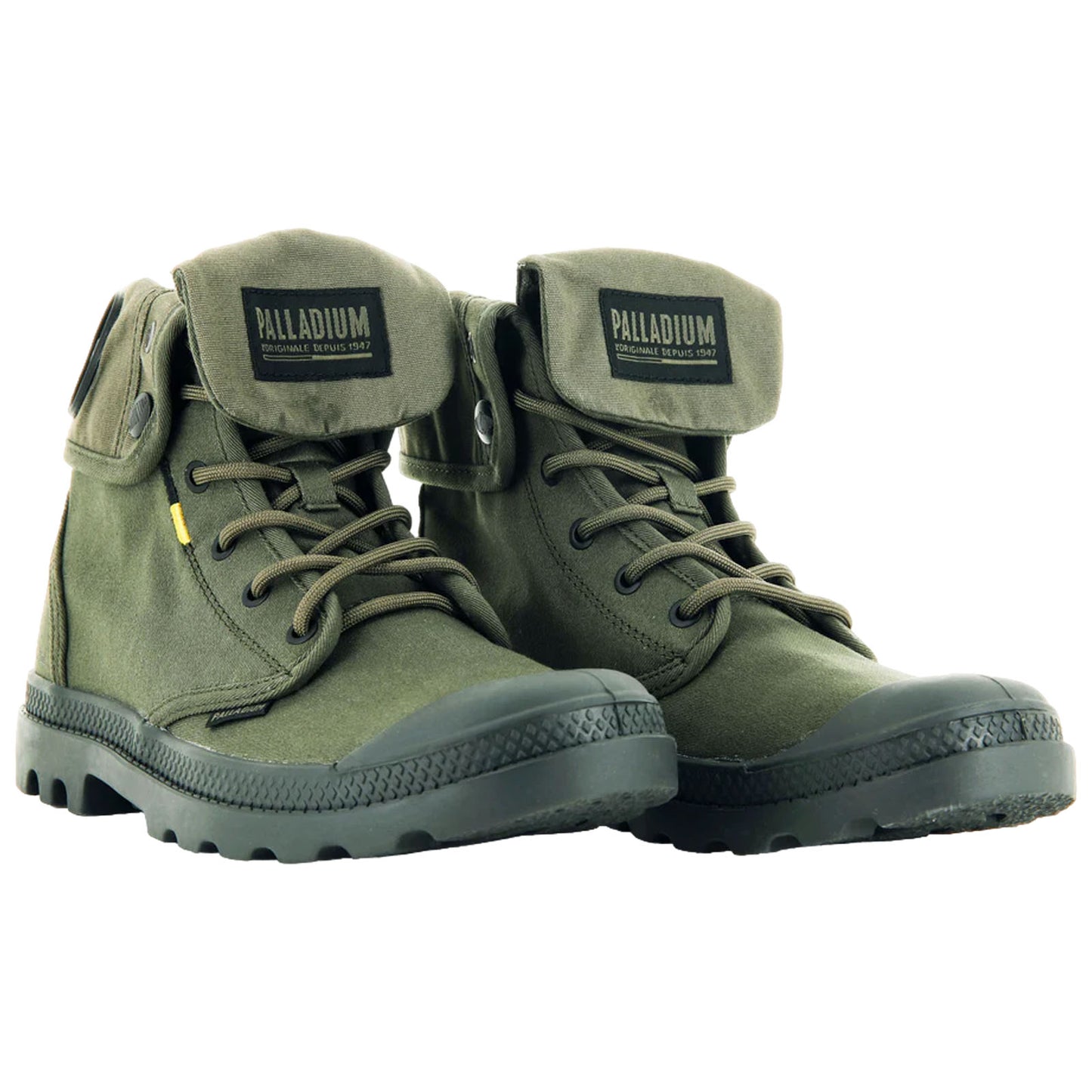 Green canvas boots with sturdy rubber soles are positioned side by side laced up and featuring a foldable top flap labeled Palladium showcasing a casual outdoor style suitable for various terrains