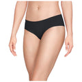 A woman is wearing black underwear while standing. Her left hand rests against her hip and her right hand is slightly raised near her side. The background is plain and light-colored.