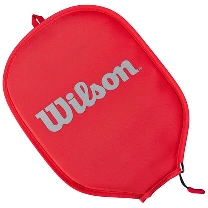 A red sports racquet cover sits upright displaying the Wilson logo prominently in silver against the red surface indicating it's designed to protect and carry sports equipment.