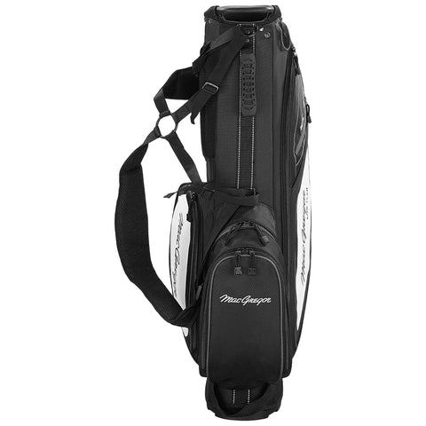 A black and white golf bag stands upright featuring multiple compartments and a shoulder strap ready for carrying on the golf course with brand name visible on the side.