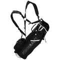A black golf carry bag with adjustable straps is positioned upright showcasing its storage compartments and branding while being ready for use on the golf course.