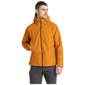 A man is standing while wearing an orange jacket with a hood. He is looking slightly to the side, showcasing the jacket in a neutral background.