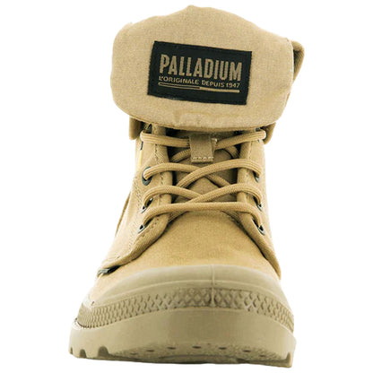 A tan boot with a folded collar displays its branding tag prominently while laces are tied. The boot suggests a casual but rugged style suitable for outdoor wear.