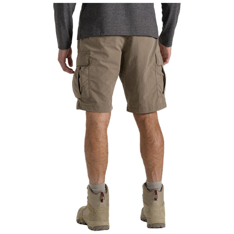 A person wears cargo shorts and hiking boots standing with their back to the viewer in an outdoor setting possibly suggestive of leisure or adventure.