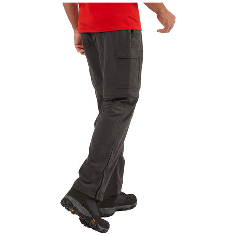 A person is walking with one leg lifted showcasing cargo pants and sturdy footwear against a plain white background, suggesting an active outdoor or casual environment.