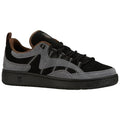 A black and gray sneaker features a suede upper with a rubber sole and sturdy laces positioned on a white background emphasizing its design and color contrast.