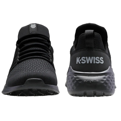 Black athletic shoes are displayed upright showcasing a mesh upper and rubber sole with a textured pattern K-Swiss branding is visible on the heel in contrasting white.