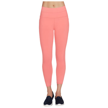 Bright pink leggings are displayed on a person standing upright wearing dark blue athletic shoes in a neutral background highlighting the legwear's fitted design and vibrant color.