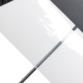 A black and white umbrella is positioned diagonally with its black canopy covering the top half and a translucent white panel on the bottom half in a neutral background.