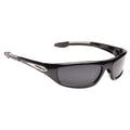 Black sunglasses rest on a flat surface featuring dark lenses and sporty design elements suitable for outdoor activities emphasizing a sleek and modern aesthetic.