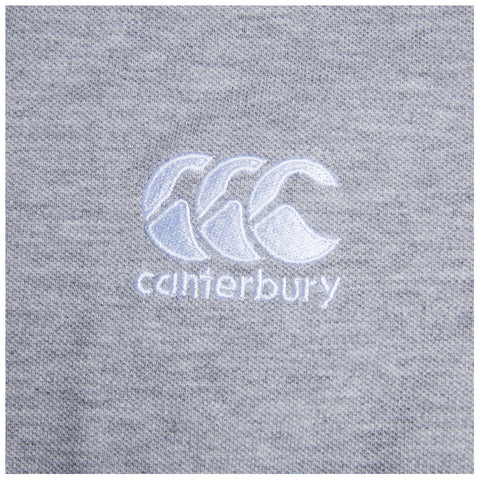 A gray textile features an embroidered logo displaying three stylized wave shapes above the word canterbury in white thread, set against a subtly textured background.