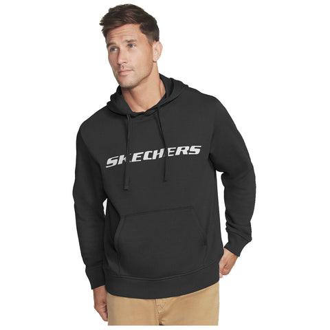 A man is wearing a black hoodie featuring the word "SKECHERS" prominently on the front. He appears thoughtful, standing against a plain background.