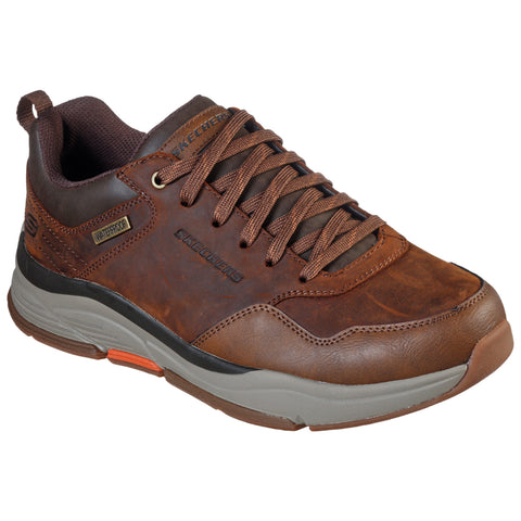 A brown waterproof sneaker features a textured leather upper with laces and a cushioned sole designed for comfort in outdoor settings. The sole has an orange accent detail.