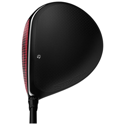 A golf club head with a sleek black and red design rests upright showcasing its smooth surface and aerodynamic shape intended for striking golf balls on a course.