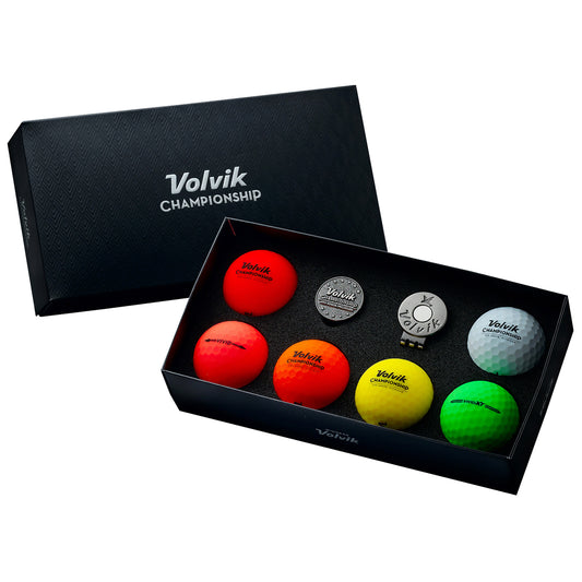 A black box displays a variety of colorful golf balls alongside a golf tee and a metal marker. The balls are labeled with "Volvik Championship" in various colors, emphasizing their design for play.