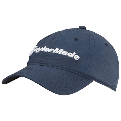 A navy blue cap displays the embroidered brand name TaylorMade prominently on the front while resting on a flat surface with smooth textures and clean lines providing a casual setting.