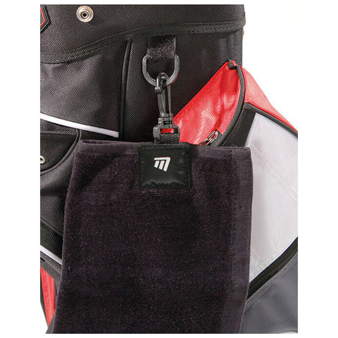 A black golf towel with a logo hangs from a small clip attached to a multi-pocketed bag in a combination of black red and gray materials, indicating organized storage for sports gear.