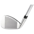 A golf club head with a shiny silver finish is positioned at an angle showcasing its grooves and face marked with horizontal lines indicating a striking surface in a neutral backdrop.