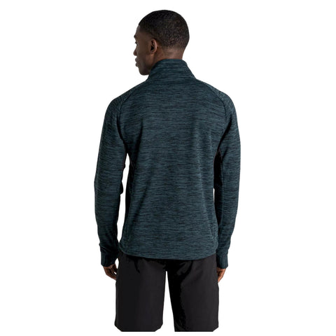 A person stands with their back facing the viewer wearing a dark, textured long-sleeve shirt and shorts in a neutral setting.