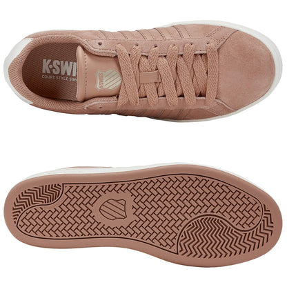Tan suede sneakers with textured laces and a rubber sole are displayed from above showcasing their sleek design and branding on the tongue with a white outsole featuring a patterned tread.
