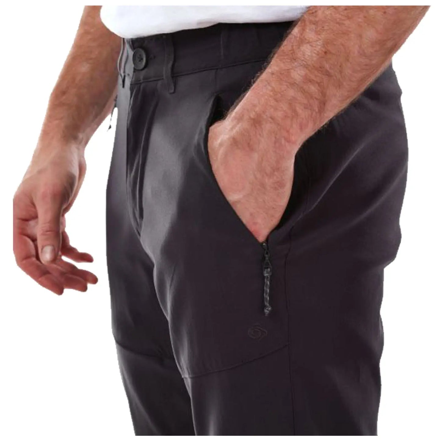A hand is positioned in the side pocket of dark-colored pants while the other hand reaches towards the pocket's edge indicating a relaxed stance in casual clothing.