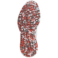 A athletic shoe sole showcases a textured pattern with red and white elements designed for traction on various surfaces in a sports or outdoor environment.