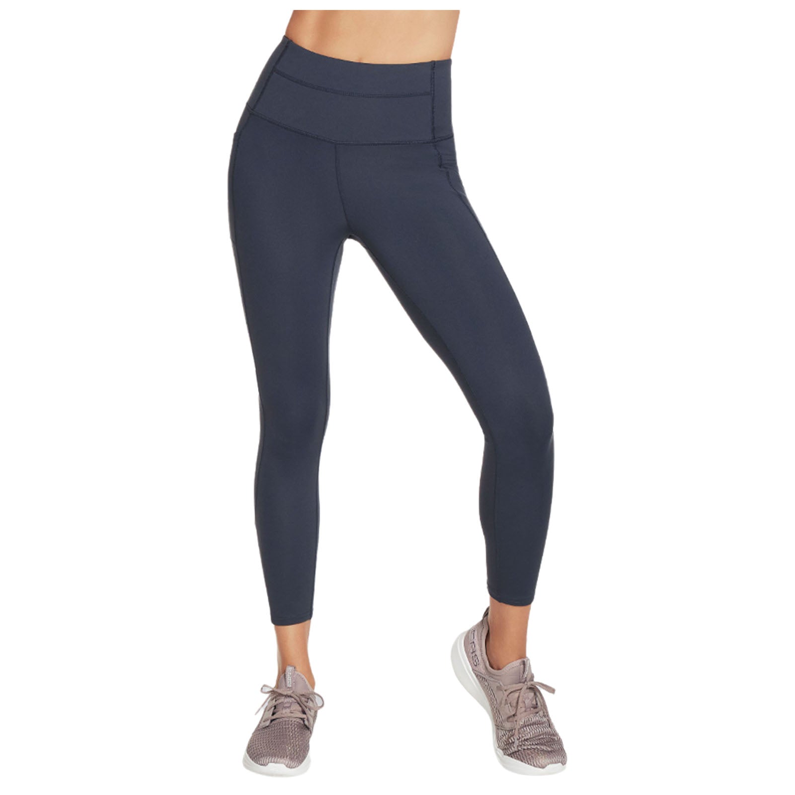 Navy leggings are worn by a person standing with one foot slightly forward while wearing light-colored athletic shoes in a neutral studio setting