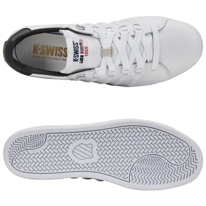A white sneaker with a black heel displays laces and a textured sole, resting flat against a background. Text on the shoe reads K-SWISS COURT STYLE SINCE 1966 and additional brand details.