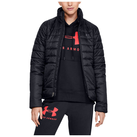 A person is wearing a black puffer jacket over a black hoodie with red lettering and matching sweatpants displaying a logo while standing confidently against a plain background.