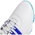 A white athletic shoe with blue accents rests on a flat surface showcasing the textured leather upper and laces featuring a combination of blue stripes and silver detailing.