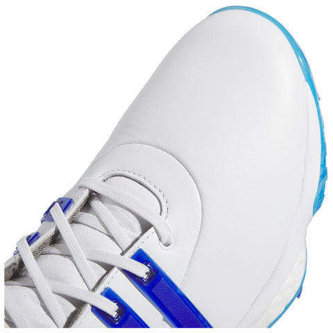 A white athletic shoe with blue accents rests on a flat surface showcasing the textured leather upper and laces featuring a combination of blue stripes and silver detailing.