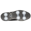 A black golf shoe sole features six clear plastic spikes arranged in two rows for traction on grass surfaces with textured patterns for grip and support during play.