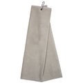 A light-colored towel is hanging from a metal clip showcasing a smooth and soft texture it is positioned upright against a neutral background suggesting utility and readiness for use.