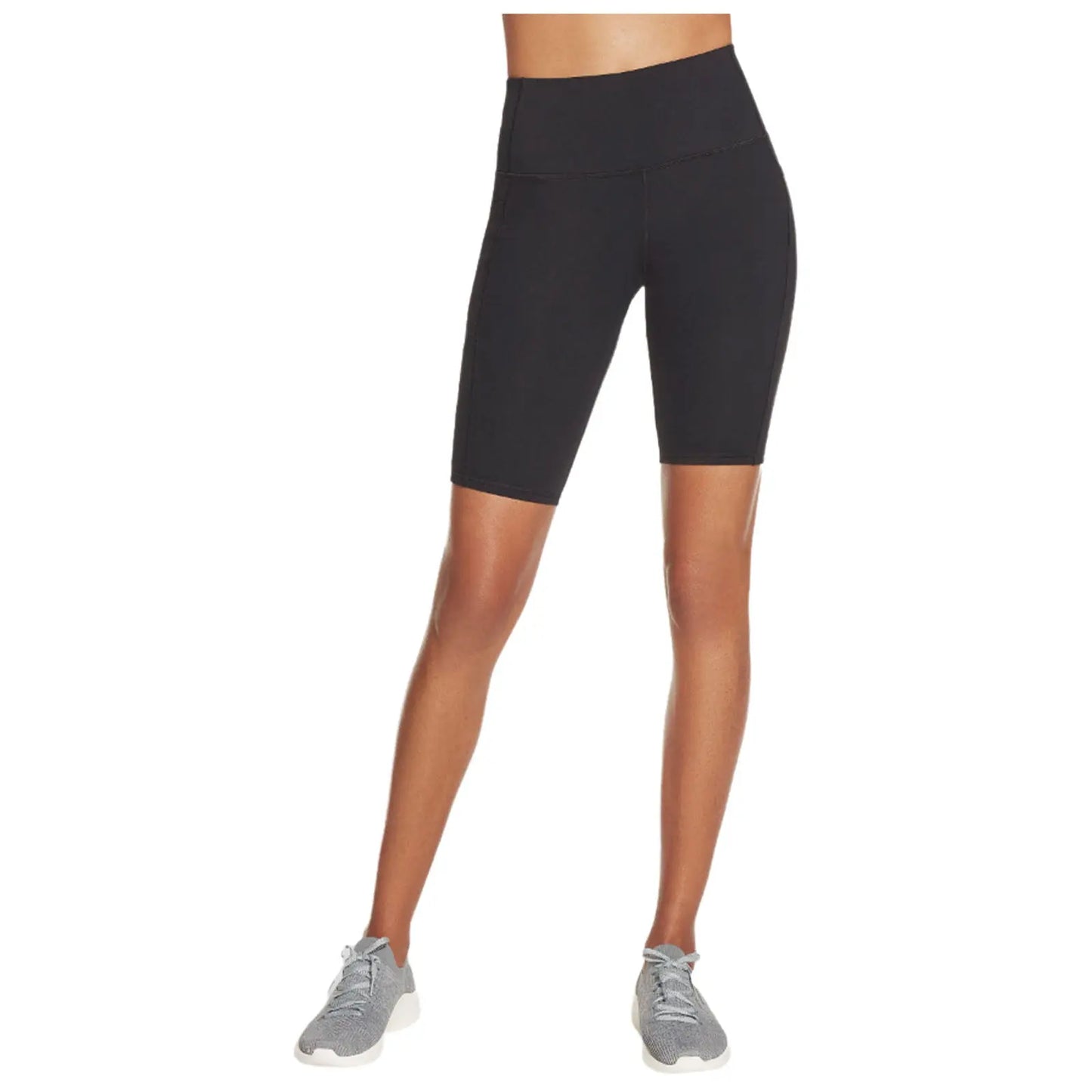 Black athletic shorts are worn by a person standing with one foot slightly forward in a neutral setting while gray athletic shoes complete the outfit and emphasize a sporty appearance.
