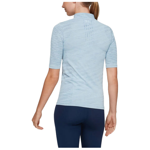 A person is standing with their back to the viewer wearing a light blue athletic shirt and dark leggings showing the shirt's textured fabric and short sleeves in a neutral background.
