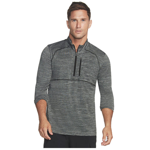 A man is standing confidently wearing a dark gray athletic pullover with three-quarter sleeves and a zipper. He has short hair and a neutral expression in a plain background.