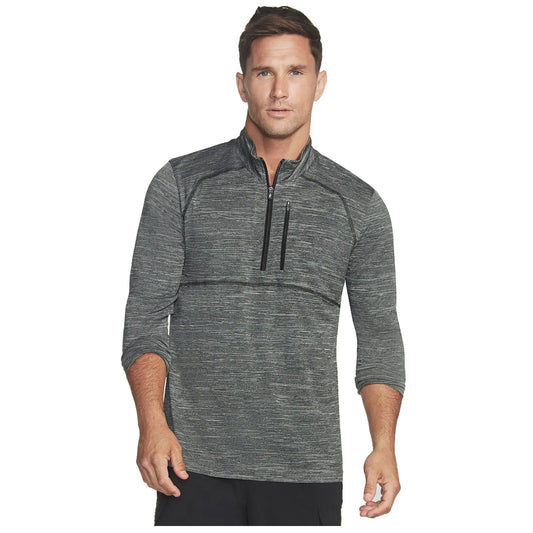 A man is standing confidently wearing a dark gray athletic pullover with three-quarter sleeves and a zipper. He has short hair and a neutral expression in a plain background.