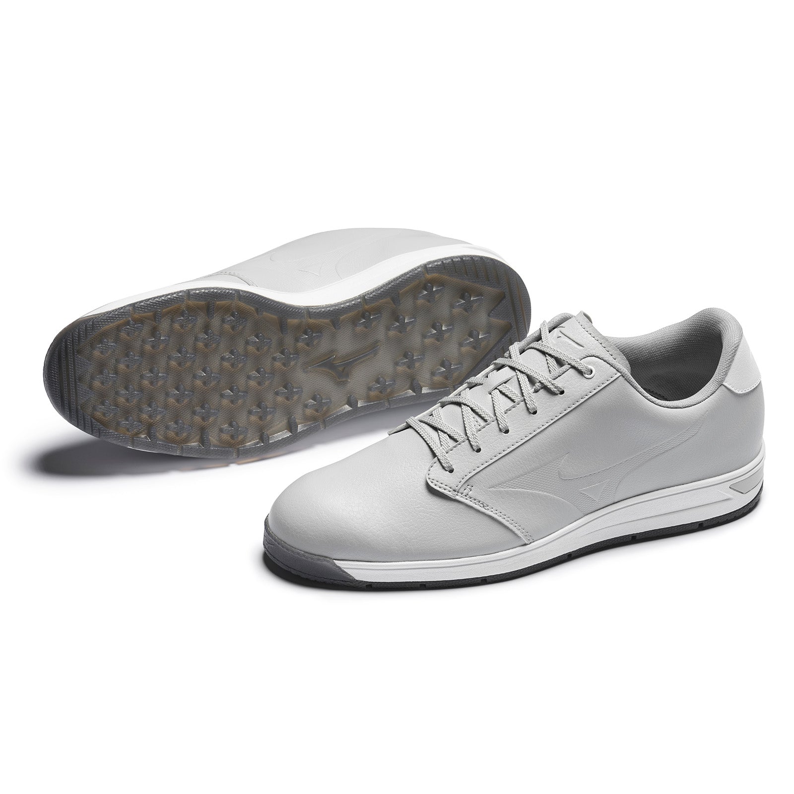 Gray athletic shoes are displayed with one shoe upright and the other on its side revealing a patterned sole suggesting a focus on performance in sports or casual activities.