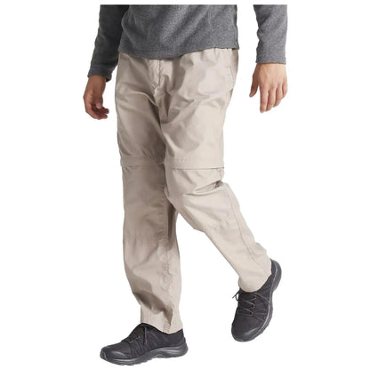 A person is walking while wearing light-colored cargo pants and dark shoes. They are dressed in a gray long-sleeve top, suggesting an outdoor or casual setting.