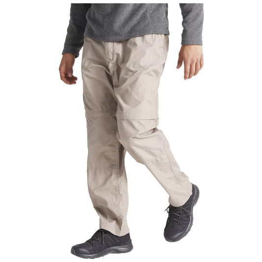 A person is walking while wearing light-colored cargo pants and dark shoes. They are dressed in a gray long-sleeve top, suggesting an outdoor or casual setting.