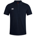 A navy blue polo shirt with short sleeves and a collar features a white Canterbury logo on the left side of the chest and three buttons down the front