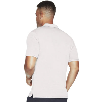 A man is standing with his back to the viewer wearing a light-colored polo shirt with short sleeves and a collar in a simple white background setting.
