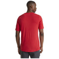 A person wearing a red short-sleeve shirt stands facing away, showing the back of the shirt in a neutral, well-lit setting without additional context or items around.