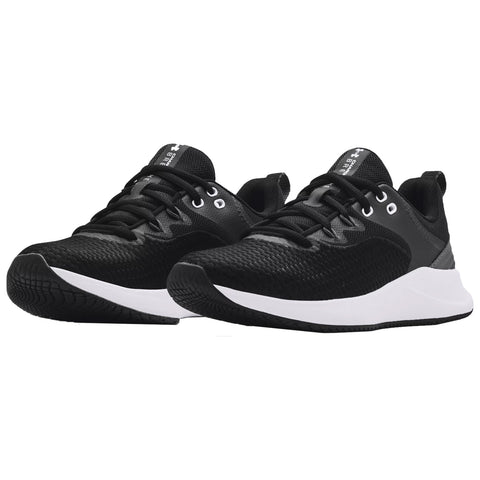 A pair of black athletic shoes with a textured surface and white soles sits side by side displaying laces and eyelets in a minimalist setting designed for sports or casual wear.