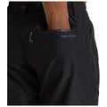 Black pants are featured with a hand inserted into a side pocket showcasing a zipper the brand name CRAGHOPPERS is visible on the fabric near the pocket