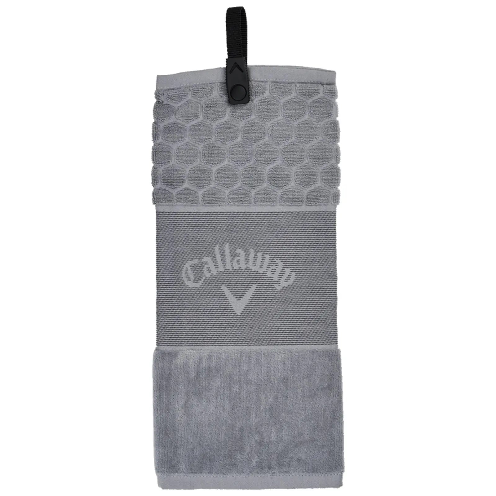 A grey golf towel hangs vertically featuring a textured hexagonal top and a soft lower section with a logo. It is equipped with a clip for easy attachment during play.