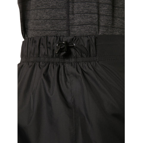 Black athletic shorts with an adjustable drawstring are being showcased close-up on a person wearing a textured gray top in an indoor setting.