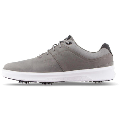 A gray golf shoe with a sleek design features spikes on the sole for traction. The shoe has a white midsole and a combination of smooth and textured materials on the upper.
