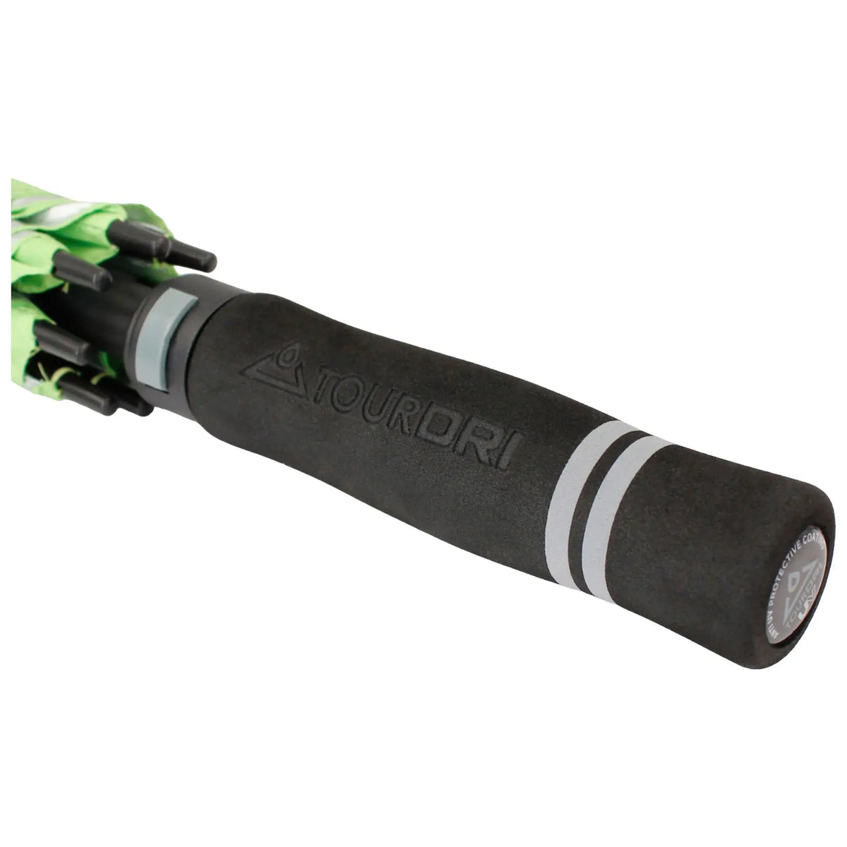 A black umbrella handle with a textured grip labeled TOURDRI is positioned prominently in the foreground while a green canopy is partially visible above it indicating readiness for rain.